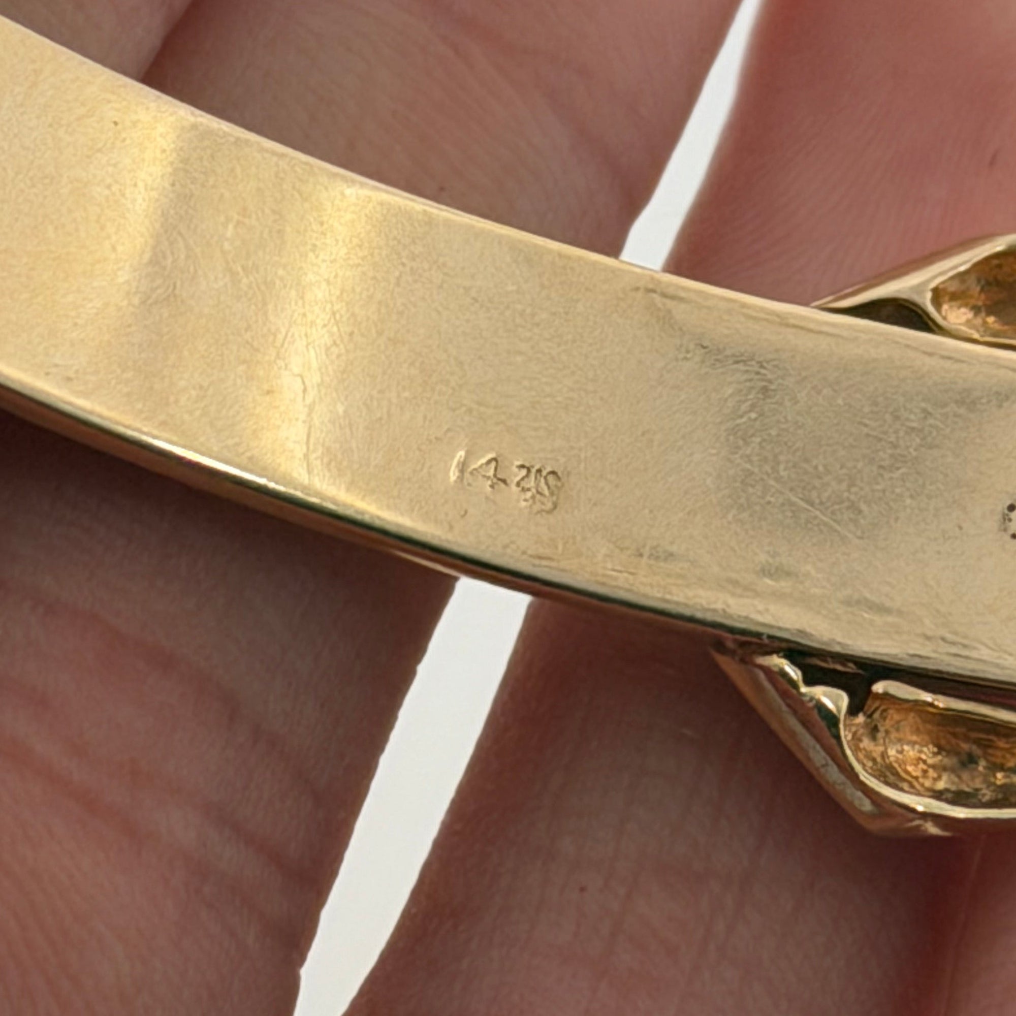 Close up of 14K stamp on the strap of a vintage yellow gold belt buckle bracelet