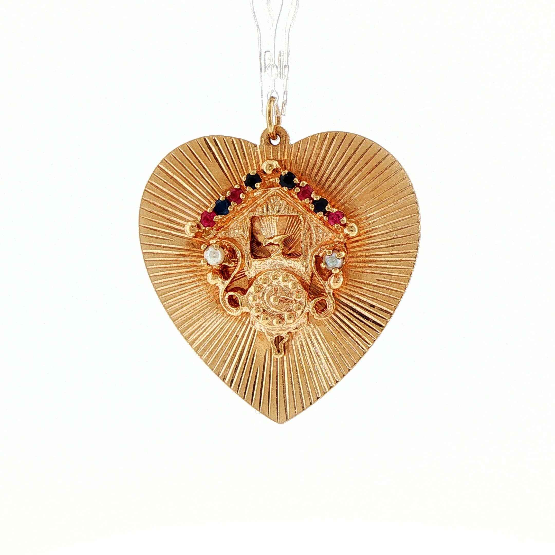 1950s 14 karat yellow gold engine-turned heart pendant, cuckoo clock motif with sapphire, ruby, and pearl accents, front view