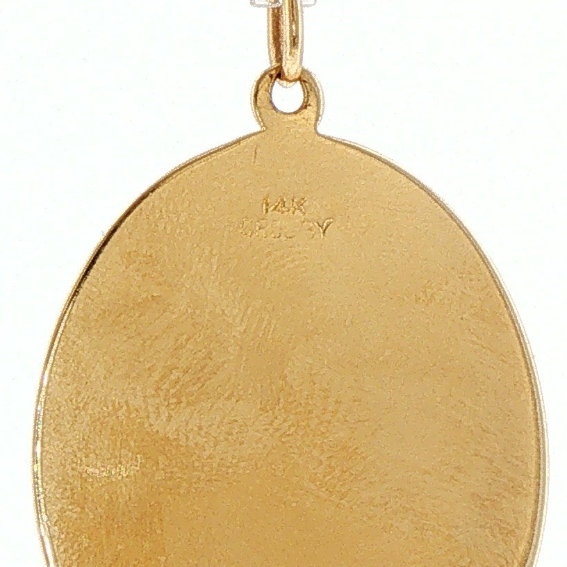Close-up of 14K hallmark stamp on engine-turned gold crown charm pendant, reverse detail