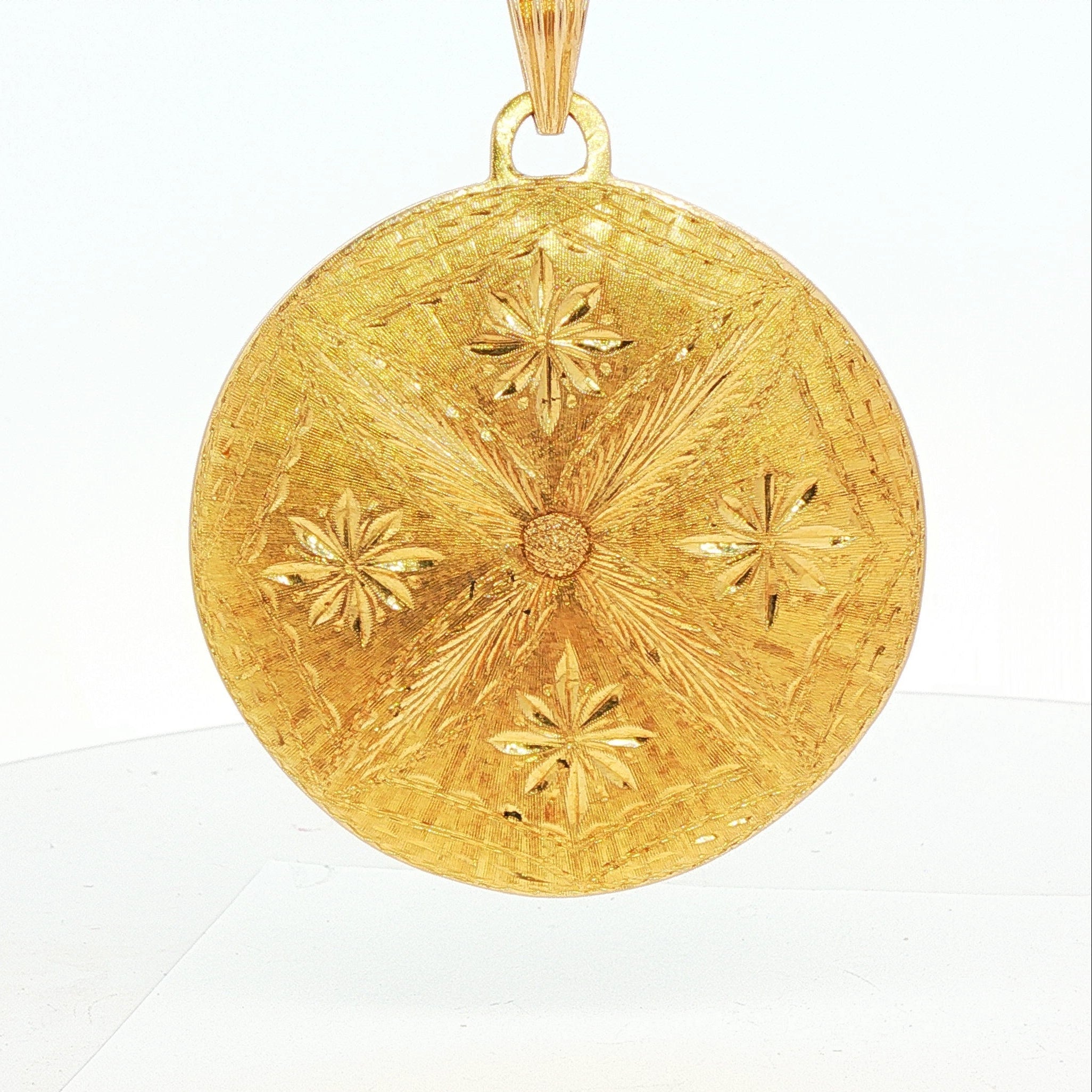 Close detail view of a 1970s Modernist Taurus zodiac pendant in 18 karat yellow gold highlighting the diamond accents, textured bull, and green enamel field