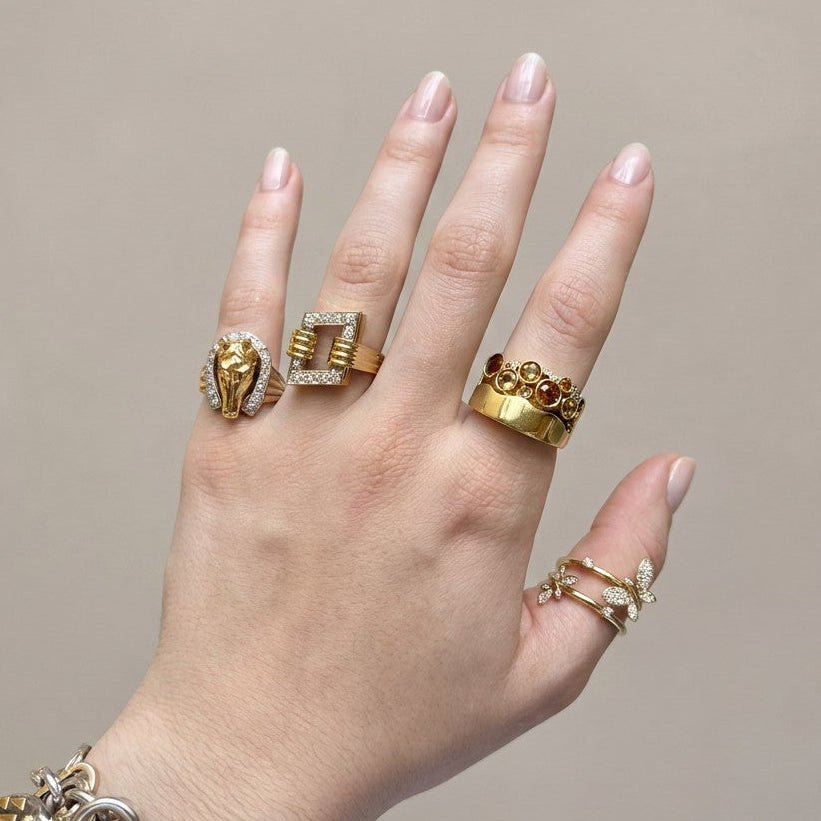 Side angle of a 1980s 18 karat yellow gold Modernist cocktail ring showing ribbed gold texture, an open frame gallery, and the raised rectangular diamond set face