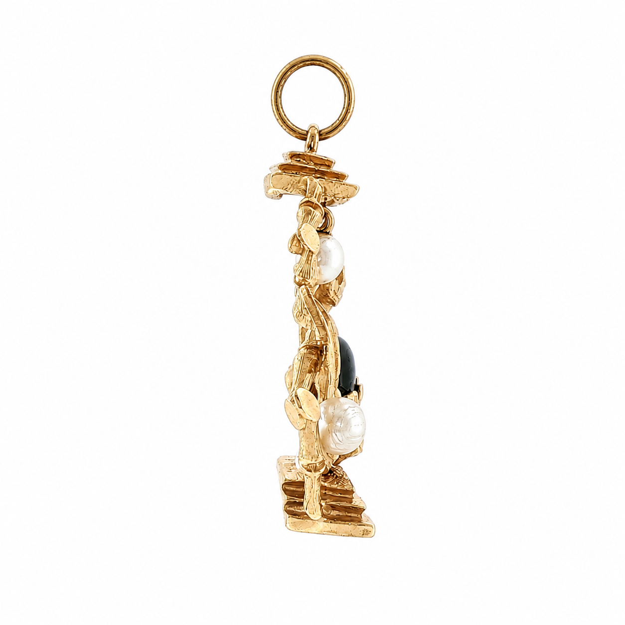 Left side view of 1960s gold Buddha charm with pearls and polished dark orb