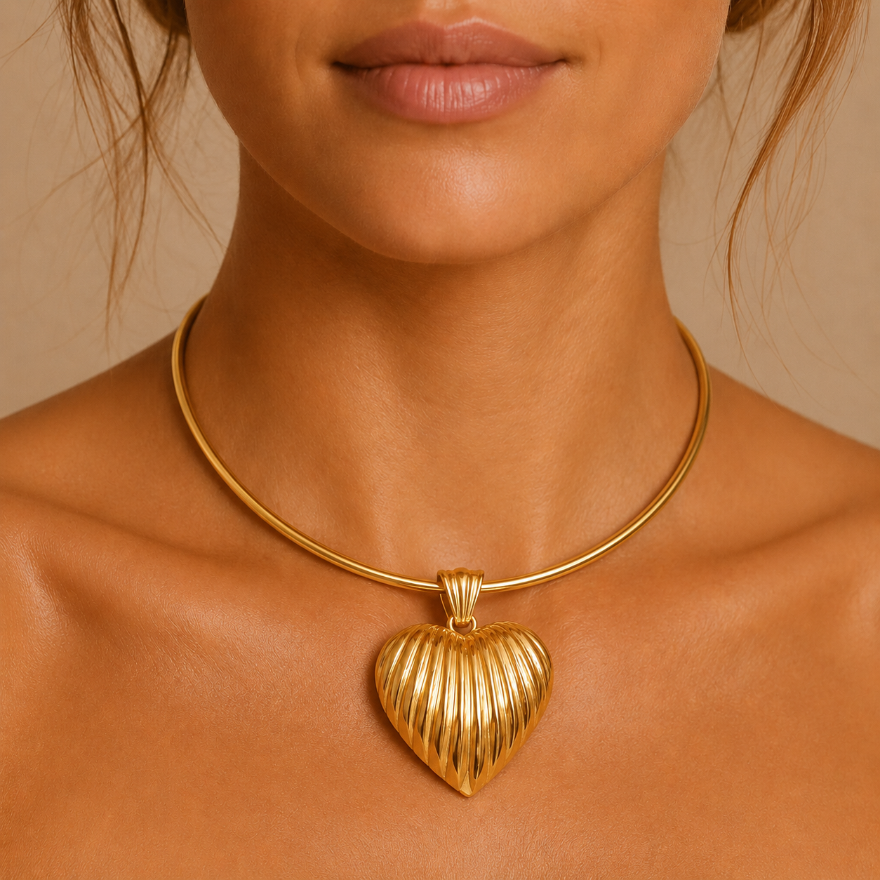 Vintage 14 Karat yellow gold puffy heart pendant worn on a woman at the base of the neck on a short gold collar