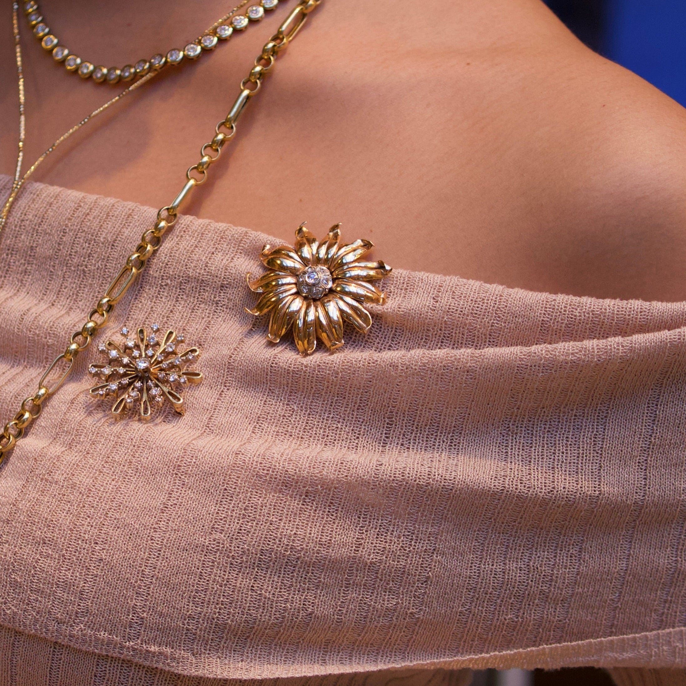 1940s Retro 18 karat rose gold flower brooch pinned to a sweater, diamond cluster center, worn detail