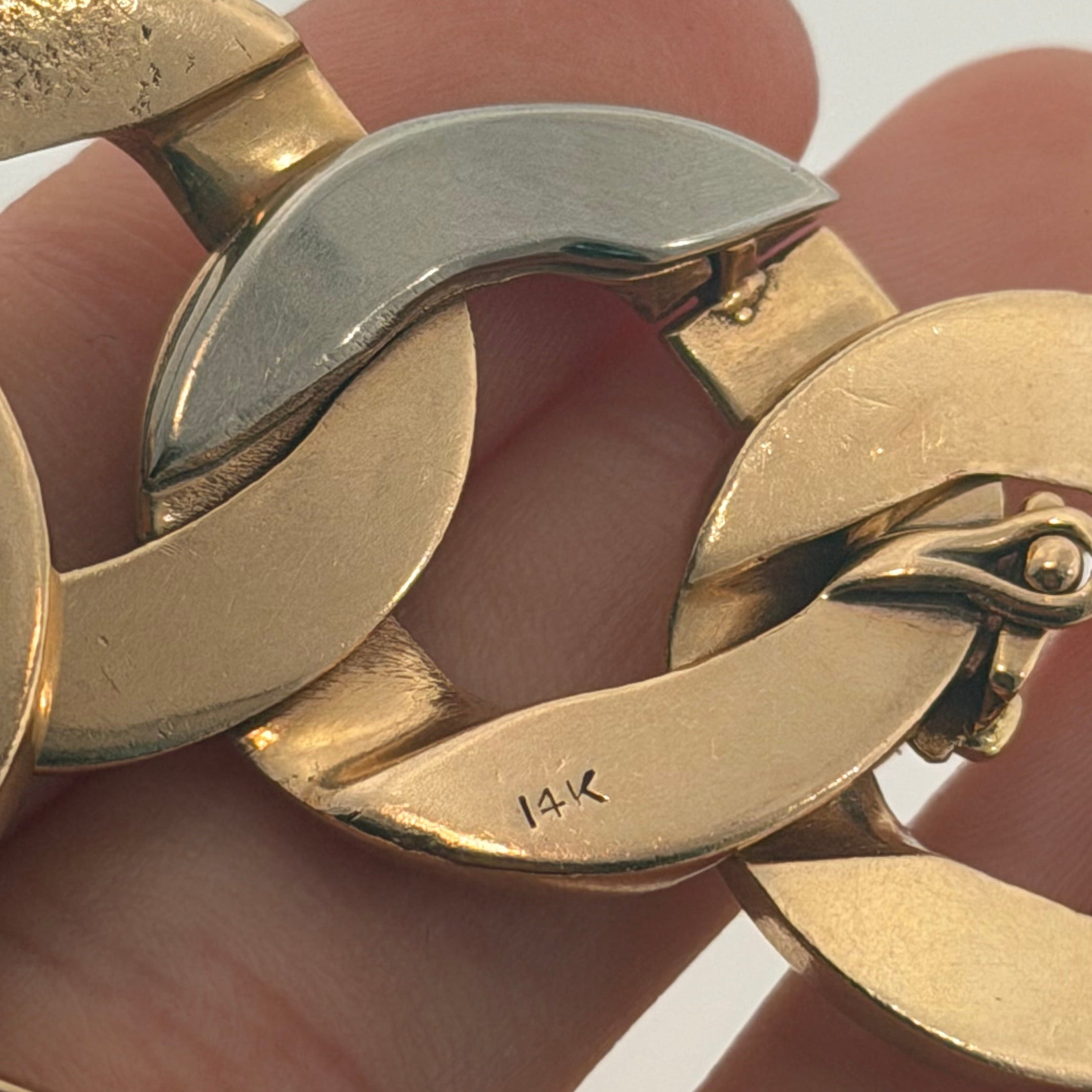 Close up of 14K stamp, white gold link and figure-eight safety catch on vintage curb bracelet