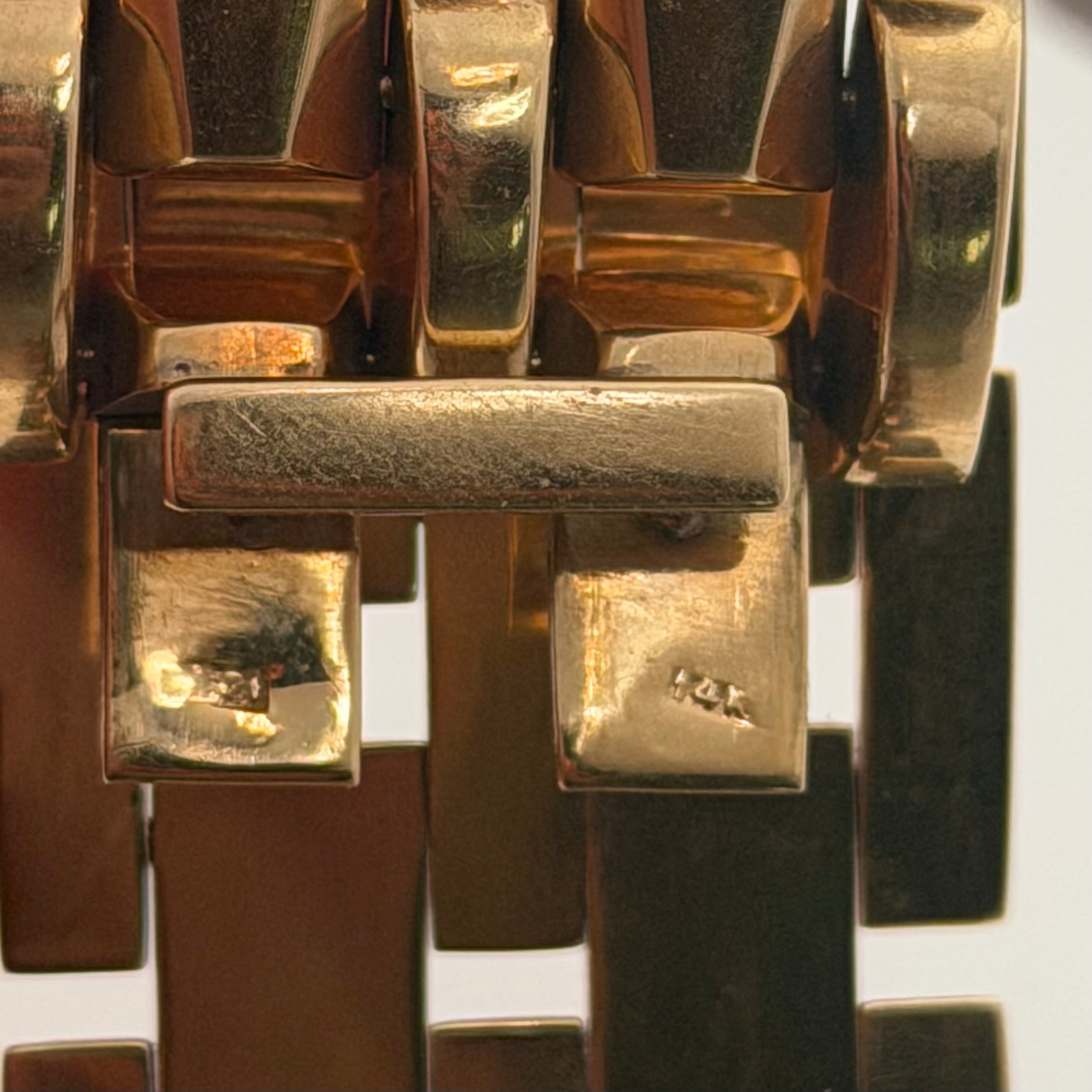 Close-up of 14K stamp on vintage yellow gold tank-style bracelet clasp area