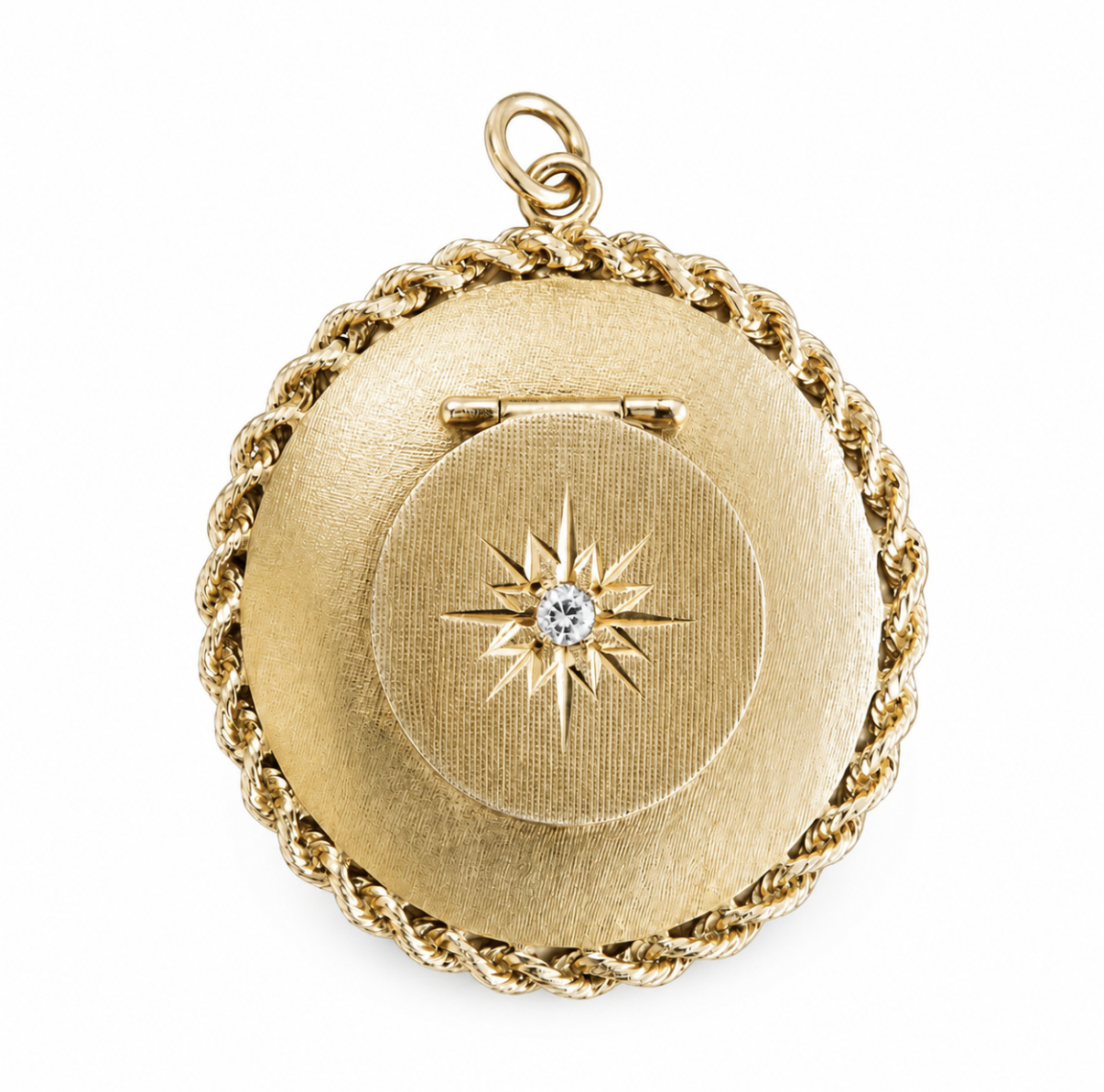 14 karat yellow gold 1950s round locket with rope-twist trim, florentine finish, and starburst diamond medallion.