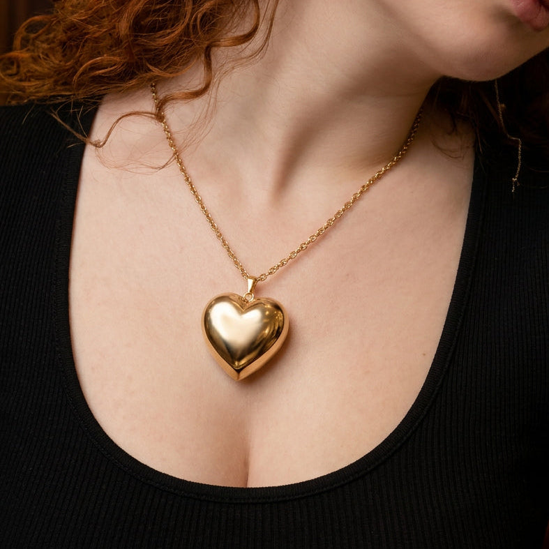 18k Gold heart-shaped necklace on a person wearing a black top