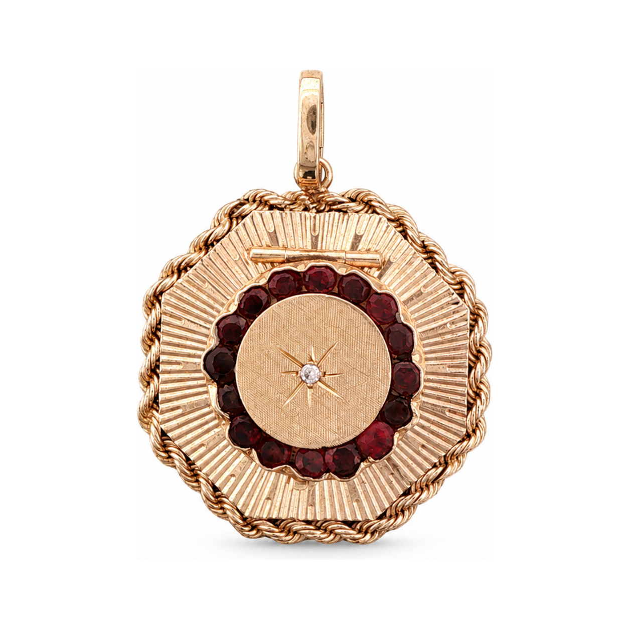 14 karat yellow gold mid-century locket with fluted sunburst rays, garnet halo, and starburst diamond center.