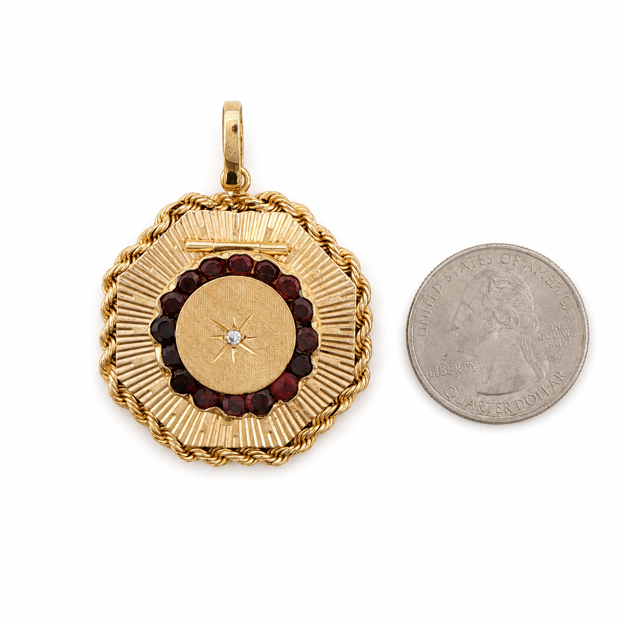 14 karat yellow gold mid-century garnet locket shown beside a US quarter for scale.