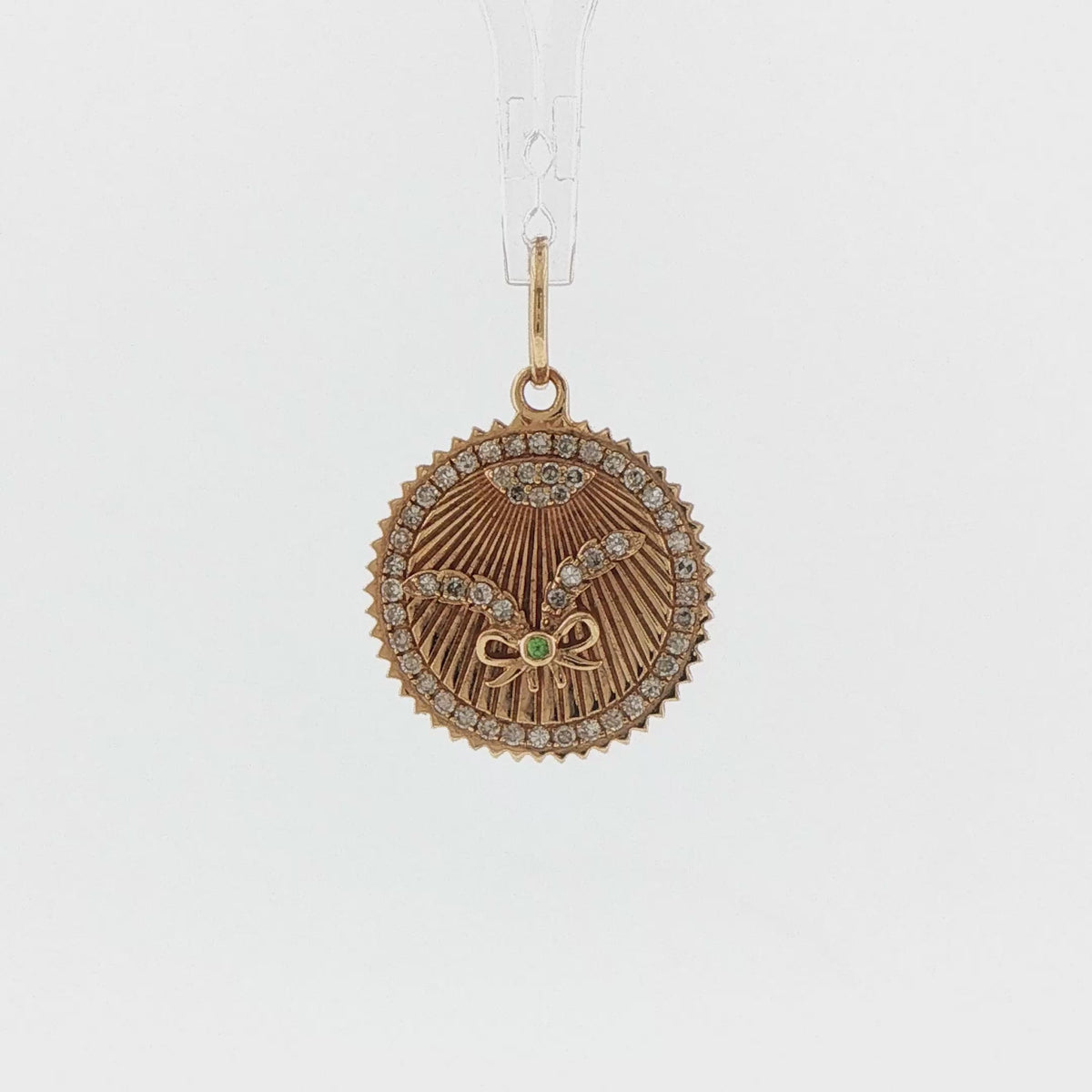 Video of a 14k yellow gold diamond and emerald crossed feather medallion charm
