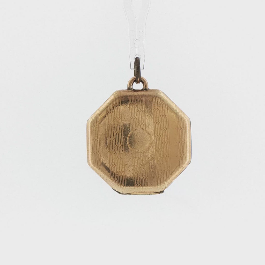 Video of a 14k gold vintage octagonal locket opening to show the photo frames